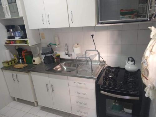 a small kitchen with a sink and a stove at Refúgio Esmeralda in Guarajuba