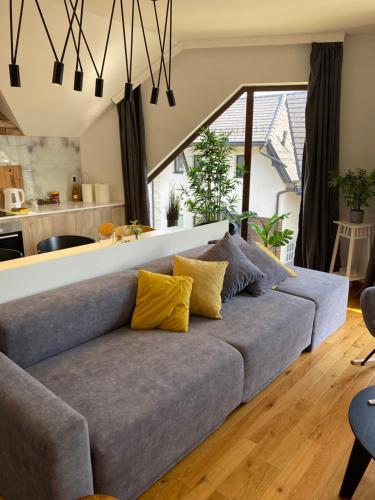 a living room with a gray couch with yellow pillows at Sunny Sight Zlatibor in Zlatibor
