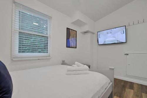 a white bedroom with a bed and a tv at Atlanta Retreat Message For Spring Special in Atlanta