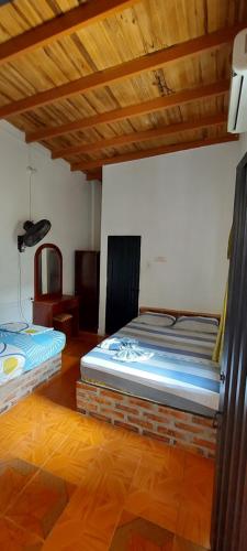 two beds sitting in a room with wooden ceilings at HOTEL CASA COLONIAL in San Antonio del Táchira