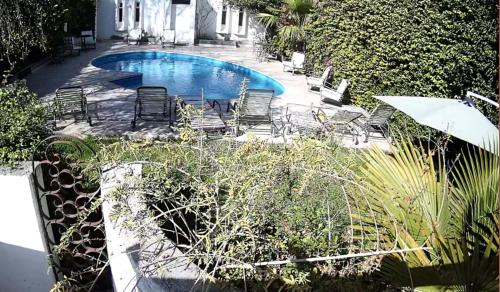 門多薩的住宿－國際酒店，一个带椅子和桌子的游泳池以及一把遮阳伞