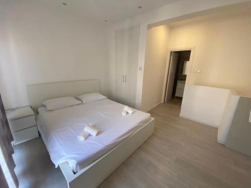 um quarto com uma cama branca com duas toalhas em 1-bedroom duplex 100m by the sea em Limassol
