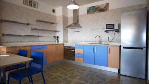 uma cozinha com armários azuis e um frigorífico de aço inoxidável em Apartamento en La Caleta El Hierro em Valverde