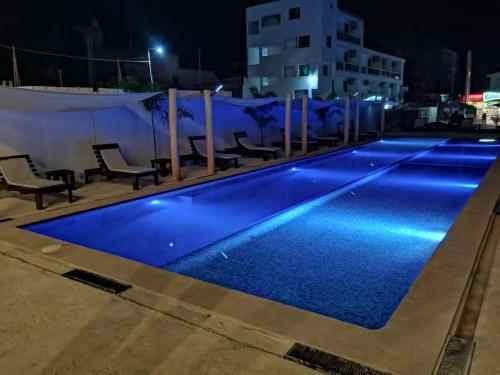 a swimming pool at night with blue lights at MALAKI in Los Ayala