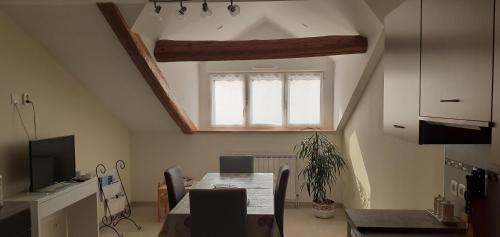 ein Esszimmer mit einem Tisch und einem Fenster in der Unterkunft gîte Les Coquelicots in Médière