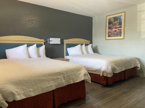 Una habitación de hotel con dos camas con sábanas blancas. en Stratford Inn, en Stratford