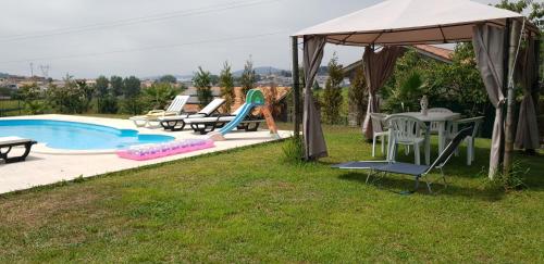 a backyard with a pool and a table and chairs at Quinta de Carvalhal - Casa de Campo in Guimarães