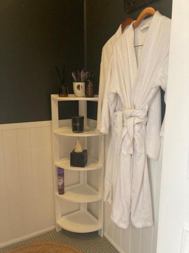 a white robe hanging on a rack in a bathroom at Burradoo Studio in Leura