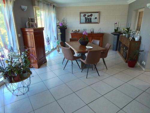 une cuisine avec une table et des chaises dans une pièce dans l'établissement Au détour des Orchidées, à Artannes-sur-Indre