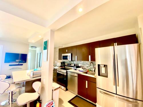 a large kitchen with a stainless steel refrigerator at Premium Modern waterfront apartment with Miami Skyline view on the bay 5 mins drive to Miami Beach with free parking in Miami Beach