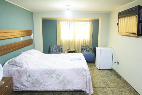 ein Schlafzimmer mit einem weißen Bett und einem Fenster in der Unterkunft Padama in Lima