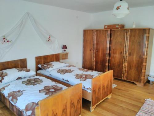 a bedroom with two beds and wooden cabinets at Holiday house with a parking space Orolik, Slavonija - 14358 in Privlaka