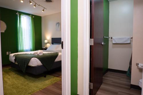ein Schlafzimmer mit grünen und weißen Wänden und einem Bett in der Unterkunft Stay Pittsburgh in Pittsburgh