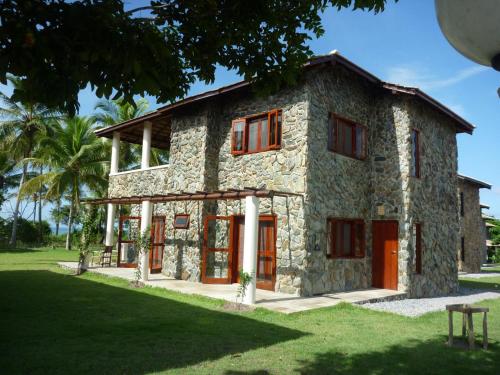 ein Steinhaus mit roten Türen und einem Hof in der Unterkunft Villa met zeezicht / nieuwstaat / gratis parkeren in Porto Seguro