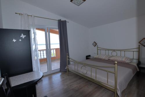 sypialnia z łóżkiem i balkonem w obiekcie Apartments by the sea Tkon, Pasman - 16589 w mieście Tkon