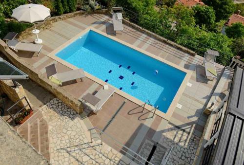 widok na basen z krzesłami i parasolem w obiekcie Holiday house with a swimming pool Rabac, Labin - 16681 w Rabacu