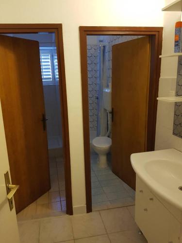 a bathroom with a toilet and a sink at Seaside holiday house Barbat, Rab - 16712 in Rab