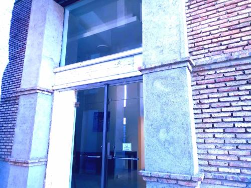 an entrance to a brick building with a glass door at Apartamento en piso 22 , con increíble vista! Ramón Bautista Mestre 1850, ANTIGUA CERVECERÍA CÓRDOBA in Córdoba