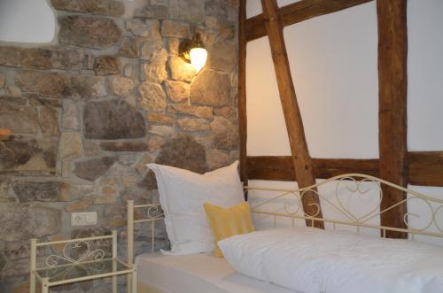 a bed in a room with a stone wall at Hotel & Café Mohrenbrunnen in Eisenberg
