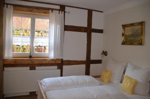 a bedroom with a white bed and a window at Hotel & Café Mohrenbrunnen in Eisenberg