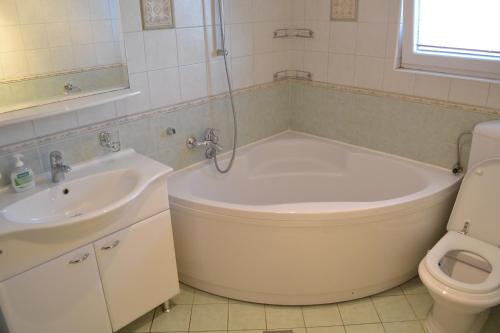 La salle de bains est pourvue d'une baignoire, d'un lavabo et de toilettes. dans l'établissement Apartments with a parking space Srima - Vodice, Vodice - 16588, à Vodice