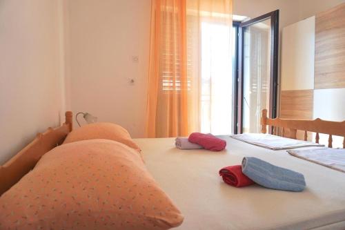 una camera da letto con un letto con cuscini e una finestra di Apartments with a parking space Senj - 16747 a Senj