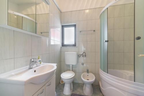 La salle de bains est pourvue d'un lavabo, de toilettes et d'une douche. dans l'établissement Apartments with a parking space Vir - 16768, à Vir