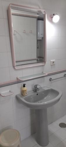 La salle de bains est pourvue d'un lavabo, d'un miroir et de toilettes. dans l'établissement APARTAMENTO EN CORRALEJO, à Corralejo