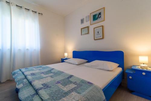 ein Schlafzimmer mit einem blauen Bett und einer blauen Kommode in der Unterkunft Apartments with a parking space Vrsine, Trogir - 16733 in Marina