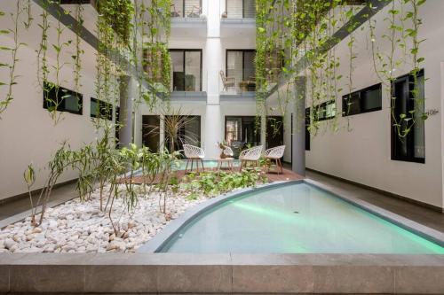 a swimming pool in the middle of a building at OneBR w Balcony or Small Studio in Playa del Carmen, BBQ, Pool Infinite, Whirlpool, AC, TV Smart, 200mb in Playa del Carmen