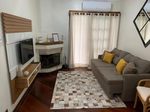 a living room with a couch and a fireplace at Apto próximo aos pontos turísticos e restaurantes in Gramado
