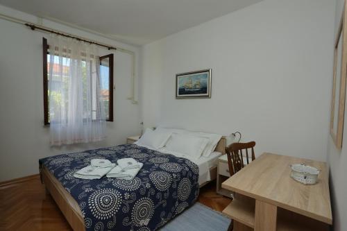 Schlafzimmer mit einem Bett, einem Tisch und einem Fenster in der Unterkunft Apartments with a parking space Supetar, Brac - 16807 in Supetar