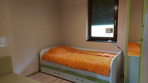a small bedroom with a bed with a window at Dvor in Donja Toponica
