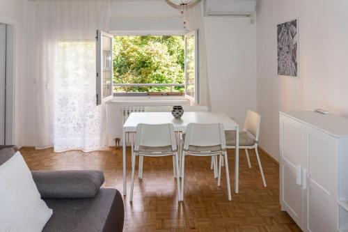 einen weißen Tisch und Stühle in einem Zimmer mit Fenster in der Unterkunft Apartments with WiFi Vinkovci, Slavonija - 16805 in Vinkovci