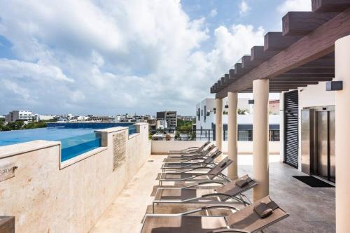 una fila de tumbonas en el techo de un edificio en OneBR w Balcony or Studio in Playa del Carmen w Balcony, BBQ, Pool Infinite, AC, TV Smart, 150mb en Playa del Carmen