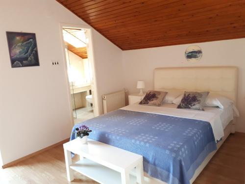 - une chambre avec un lit et une couette bleue dans l'établissement Apartments by the sea Petrcane, Zadar - 16828, à Petrčane