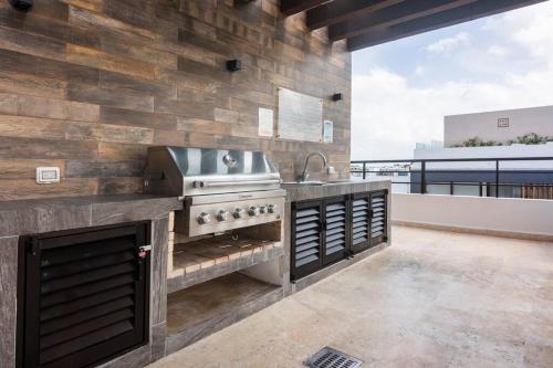 an outdoor kitchen with a sink and a stove at OneBR w Balcony or Studio in Playa del Carmen w Balcony, BBQ, Pool Infinite, AC, TV Smart, 150mb in Playa del Carmen
