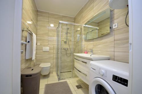 a bathroom with a shower and a sink and a washing machine at Apartment Tribunj 16884b in Tribunj