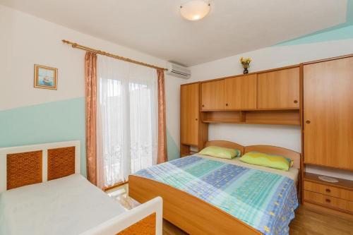 um pequeno quarto com uma cama e uma janela em Apartments with a parking space Kastel Stafilic, Kastela - 16811 em Kaštela