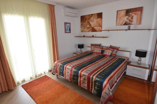 ein Schlafzimmer mit einem Bett mit einer bunten Bettdecke in der Unterkunft Apartments with a parking space Okrug Gornji, Ciovo - 16935 in Trogir