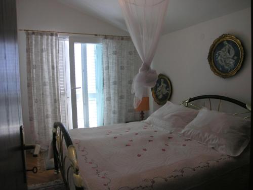 Schlafzimmer mit einem Bett mit weißer Bettwäsche und einem Fenster in der Unterkunft Seaside holiday house Drvenik Veliki, Drvenik - 16937 in Drvenik Veli