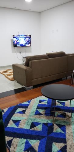 - un salon avec un canapé, une table et un tapis dans l'établissement Casa alto padrão Capitólio Lago Vitória, à Capitólio