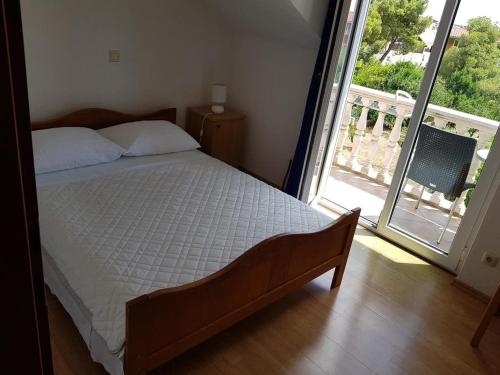a bedroom with a bed and a large window at Apartment Okrug Gornji 17032c in Trogir