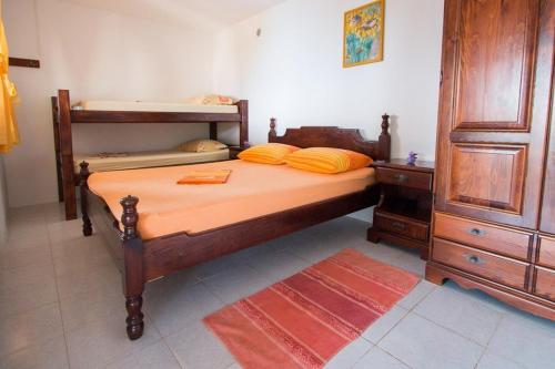 1 dormitorio con 1 cama y 1 litera de madera en Secluded fisherman's cottage Cove Spiljice, Brac - 17031 en Selca