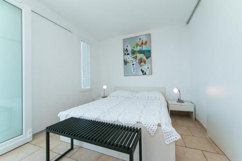 biała sypialnia z łóżkiem i ławką w obiekcie Apartments with a parking space Brela, Makarska - 16596 w Breli