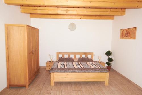 1 dormitorio con cama de madera y armario de madera en U Haryho en Dolní Bečva