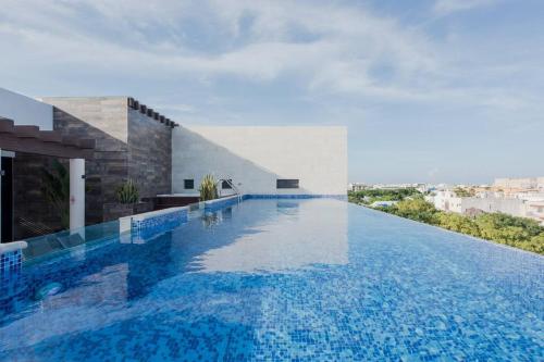 a swimming pool in the middle of a building at OneBR w Balcony or Small Studio in Playa del Carmen, BBQ, Pool Infinite, Whirlpool, AC, TV Smart, 200mb in Playa del Carmen