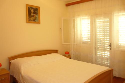 - une chambre avec un lit et une fenêtre avec des volets dans l'établissement Apartments by the sea Prizba, Korcula - 16900, à Prižba