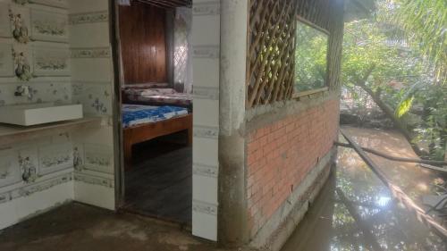 a room with a brick wall and a window at mekong floating market Nam Giang homestay in Cai Be