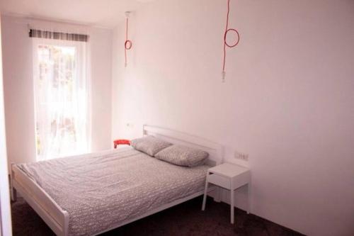 a white bedroom with a bed and a window at Apartments by the sea Sveti Filip i Jakov, Biograd - 16966 in Sveti Filip i Jakov